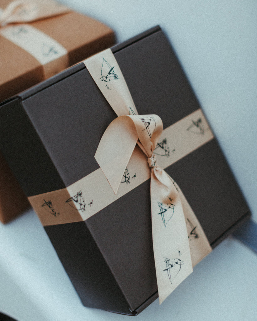 Two gift boxes with decorative ribbons on a light blue background